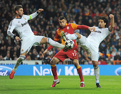 Burak Yilmaz of Galatasaray is challenged by Sergio Ramos (L) and Sami Khedira of Real Madrid during the UEFA Champions League Quarter Final first leg match. Net photo.