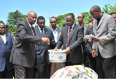High Commissioner Mugambage  (2L) and Rakai Resident District Commissioner, David Kaboyo, (L) pay respect to victims of the Genocide against the Tutsi  at Kasensero, Rakai, Uganda. The....