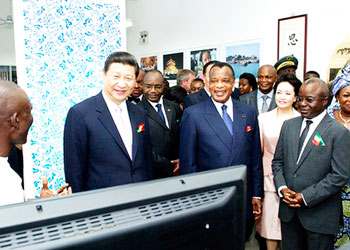 Chinese President Xi Jinping (2nd L) listens to an IT geek in Congo Brazzaville during his recent tour of the continent. Jinping said the with the global economy undergoing profound an....