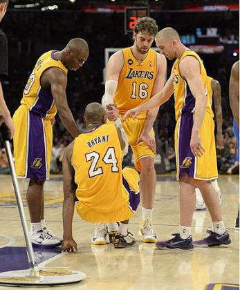 Los Angeles Lakers shooting guard Kobe Bryant (24) is helped up by teammates against the Golden State Warriors during the game at Staples Center. Net photo.