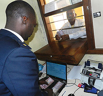 A trader pays tax at a customs point at Rusumo border. Tanzania and Rwanda have agreed to support small cross-borders traders. The New Times/ File.