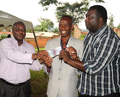 Serena Hotel Country Manager, Charles Muia (L), hands a cheque to the President of Abahumurizanya Association David Tuganimana (C) and CNLG's Gaspard Gasasira yesterday. The Sunday Times, John Mbanda.