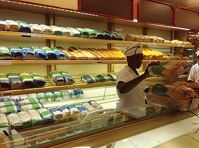  A worker packing bread at a store in town. The prices of bread are bound to rise as bakers try to cover operations costs. The New Times / Peterson Tumwebaze