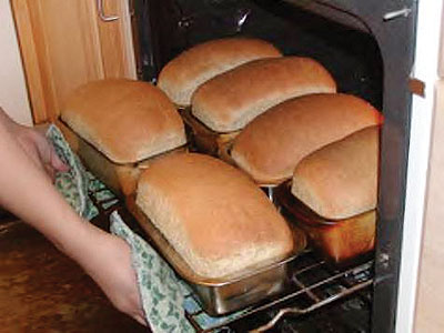 A worker at La-Galette removes bread from an oven. Bakers say they facy several challenges. The New Times / P. Tumwebaze