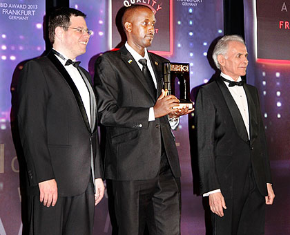 Wilson Musonera (C) poses with e-Soko award. He is flanked by Jose E. Prieto, the executive president of Business Initiative Directions (R) and another guest during the awards. e-Soko won the International Arch of Europe Award for its outstanding quality data prices that has helped farmers and buyers to access daily commodity prices in the market.  The New Times/ Courtesy.