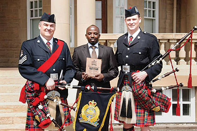 Muganga (middle) poses with his award. The New Times / Courtsey photo