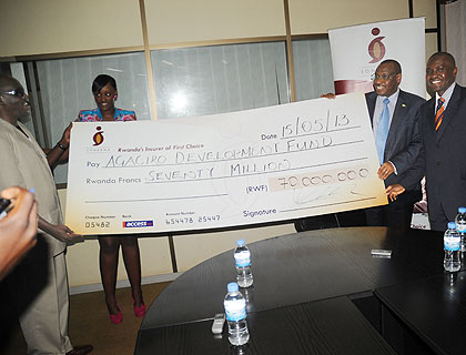 Finance minister Claver Gatete (2ndR) and Dr Ndahiro show Sonarwau2019s dummy cheque for the contribution.   The New Times/ John Mbanda.