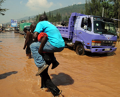 A man is carried across a flooded road. The Western Province is prone to disasters such as floods and mudslides, among others.   Saturday Times/File. 