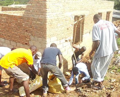 Students of SFB constructing the house. The New Times / Courtesy.