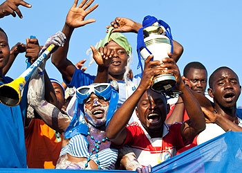 Rayon Sports' fans carry dummy trophies after their team won the league last week. The New Times / T. Kisambira.