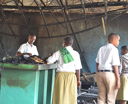 Students of Byimana School of Sciences  inspect the burnt school chapel and dormitory after the second fire razed the buildings early this week.  The New Times/ File.