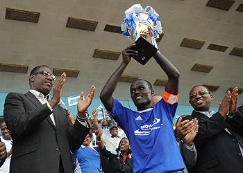 Rayon Sports skipper Aphrodis Hategikimana lifts the Primus League title yesterday at Amahoro Stadium. Looking on is Sports and Culture Minister Protais Mitali (L). The Sunday Times / J. Mbanda.
