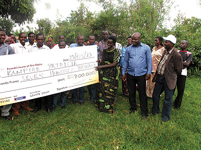 Kampire (second, right) receiving a dummy cheque of her compensation on Thursday. The New Times / Stephen Rwembeho