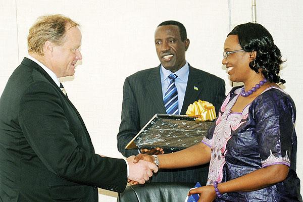 Dirk Niebel (L), the German Federal Minister for Economic Cooperation and Development, receives gifts from Speaker Rose Mukantabana and Senate President Jean Damascu00e8ne Ntawukuriryayo at Parliament Building.