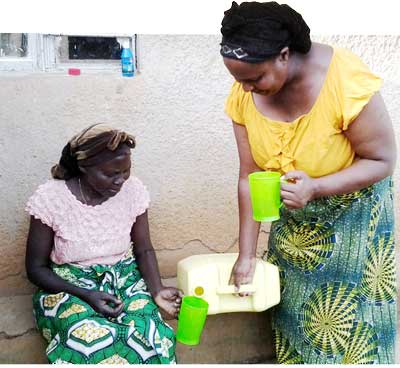 Mukarutwaza prepares to discant Suru2019Eau into a jerrycan, and left, she shares the clean water with her neighbour, Mukashema. The New Times/ Courtesy.