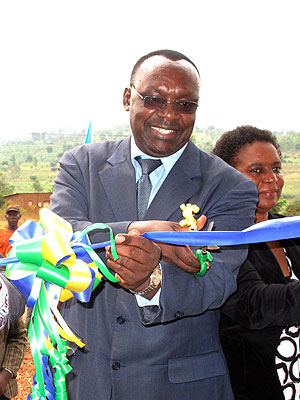 Min. Francis Kanimba cutting a ribbon to officially open one of the SACCOs. Sunday Times / S. Rwembeho.