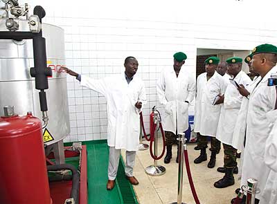 Niyibizi Ananie, a senior research technician at the IRST Kigali research station, explains to Rwanda Defence Forces personnel how bio-disiel is produced. The New Times / T. Kisambira