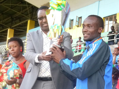 Sports Minister Protais Mitali gives the trophy to AS Kigali skipper Jimmy Mbaraga after the 3-0 win over AS Muhanga at Amahoro Stadium. Sunday Times/Courtesy