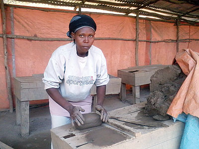 Rebecca Muberarugo molding bricks.