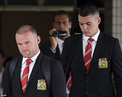 Short trip- Rooney (left) arrives in Bangkok, but the forward is to fly home immediately. Net photo.