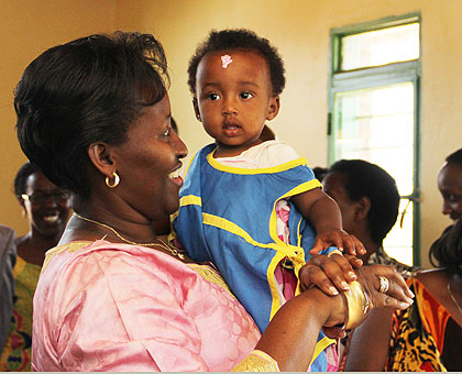 Mrs Kagame carries one of the children at the Early Childhood Development and Family Centre. Saturday Times/Timothy Kisambira.