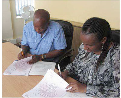 Joseph Mukama, the director of Rusororo Aggregate  and Fusionu2019s Kageenu sign the deal. Courtesy photo