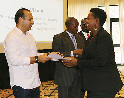 Camberos (left) handing over a certificate to one of the 18 students who were awarded MBAs last week. The New Times / Peterson Tumwebaze