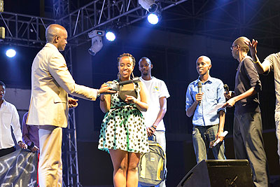 Teta picks up her award as other winners look on. 
