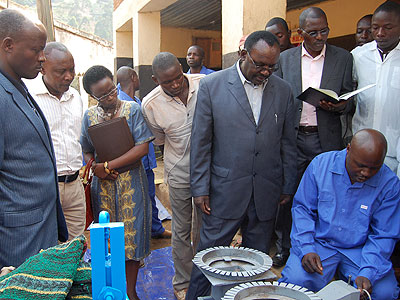 Kanimba (C) gets closer to inspect Nteziryayou2019s technical expertise in electronics and machinery repair during his tour of SMEs in Rulindo District on Tuesday. The New Times/Jean d'A....