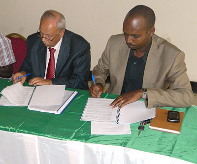 Tunisia Volleyball Federation chairman Mr. Mounir Ben Slimane and FRVB Chairman Gustave Nkurunziza signing the agreement yesterday in Kigali. The New Times / P. Kamasa.
