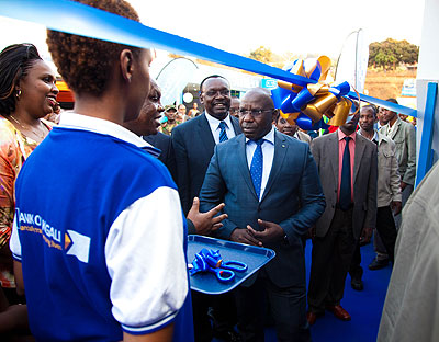 Premier Pierre Habumuremyi is briefed just before he cuts the ribbon to launch Expo 2013 yesterday. 