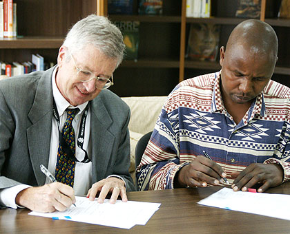Amb. Koran (L) and one of the representatives of the beneficiary Saccos sign the fund agreement on Wednesday. Courtesy.