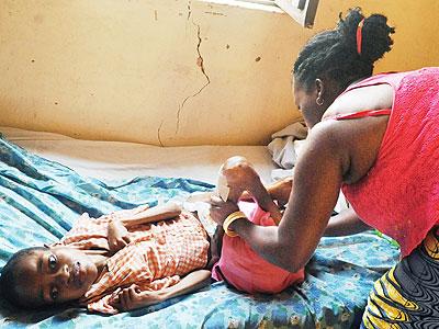 Jeanine Kankera attends to Esperance at their home in Kinyinya. Sunday Times/John Mbanda