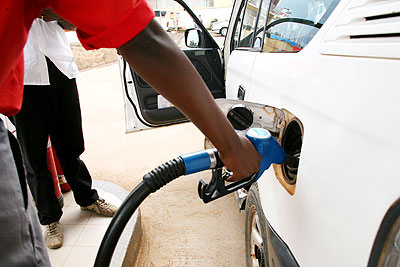 A fuel pump attendant fills a car. Prospecting oil in the country will be a major step in boosting the countryu2019s oil sector.   The New Times/ File.