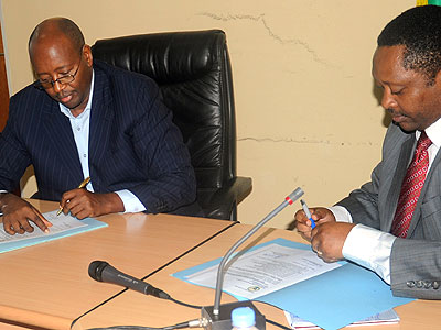 Musoni (L) and Shyaka sign at the handover yesterday. The New Times/John Mbanda