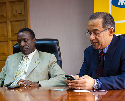 Senate president Jean Damascene Ntawukulilyayo and MTN Rwanda CEO Khaled Mikkawi activate their SIM cards during a registration exercise. The New Times/ Timothy Kisambira.