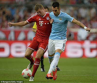 Bayern's Toni Kroos holds off a challenge from new City signing Alvaro Negredo. Net photo