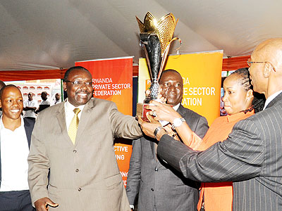 Kanimba (L) awards Tigo, the overall best exhibitor, at the close of Expo 2013 yesterday. The New Times/John Mbanda.