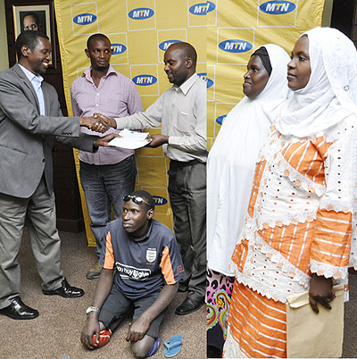 LEFT: Sheikh Iyakaremye (R) receives the cheque from Uwizeye at the MTN headquarters in Nyarutarama on Wednesday, as Muslim youth foundation officials look on (right). The New Times/ T....