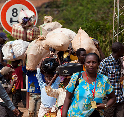 Expelled Rwandans cross back from Tanzania at the weekend, while below some of the refugees carry the only property they can afford to on their journey of absurdity. The New Times/ T. ....