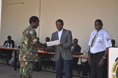Dr Biruta (R) awards a certificate to one of the participants at this yearu2019s Itorero training. The minister urged the youth to remember their debt to the country. The New Times/ Iren....
