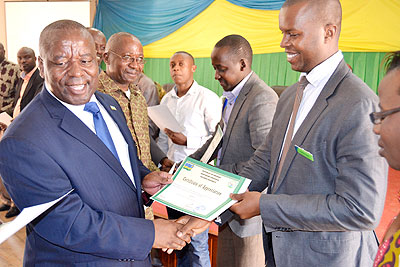 Bosenibamwe (L) awards a certificate of appreciation to Rulindo best performers. The New Times/ Jean Mbonyinshuti.