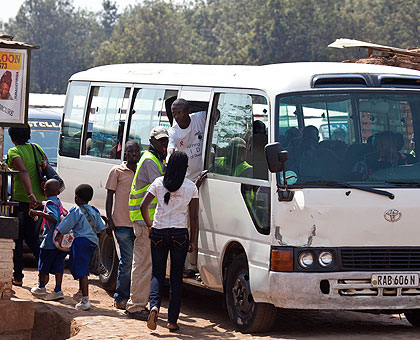 Passengers board a mini-bus at Gisementi stage in Remera. A new transport policy in the City of Kigali will soon be rolled out after three transport operators won bids to manage specif....