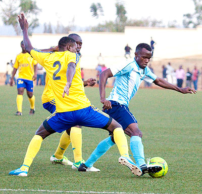 Police FC striker Peter Kagabo has his way blocked by KCCA veteran defender Richard Maliga (#2) during Sunday's friendly match at Stade de Kigali. Times Sport / T. Kisambira.