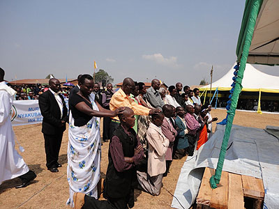 Ten Genocide convicts (kneeling) reconciled with relatives (standing) of those they killed after attending a reconciliation programme. Saturday Times/JP Bucyensenge