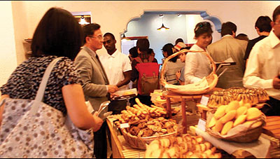 Some of the guests at the opening of the coffee shop serve themselves eats. The New Times / Collins Mwai