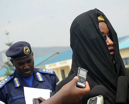 One of the victims in the human traffiking racket speaks to the media yesterday. Left is  Police spokesperson Badege   The New Times/ John Mbanda.