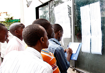 Students at the School of Finance and Banking check their marks on the notice board.  The New Times/ File.