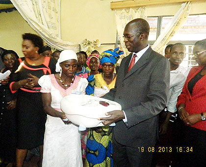 Murekezi (R) hands over a hair saloon equipment to one of the beneficiaries The New Times/ Courtesy .