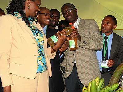 Dr. Kalibata (L) and other officials examine bottles of banana juice during the conference in Kigali yesterday. The New Times/John Mbanda